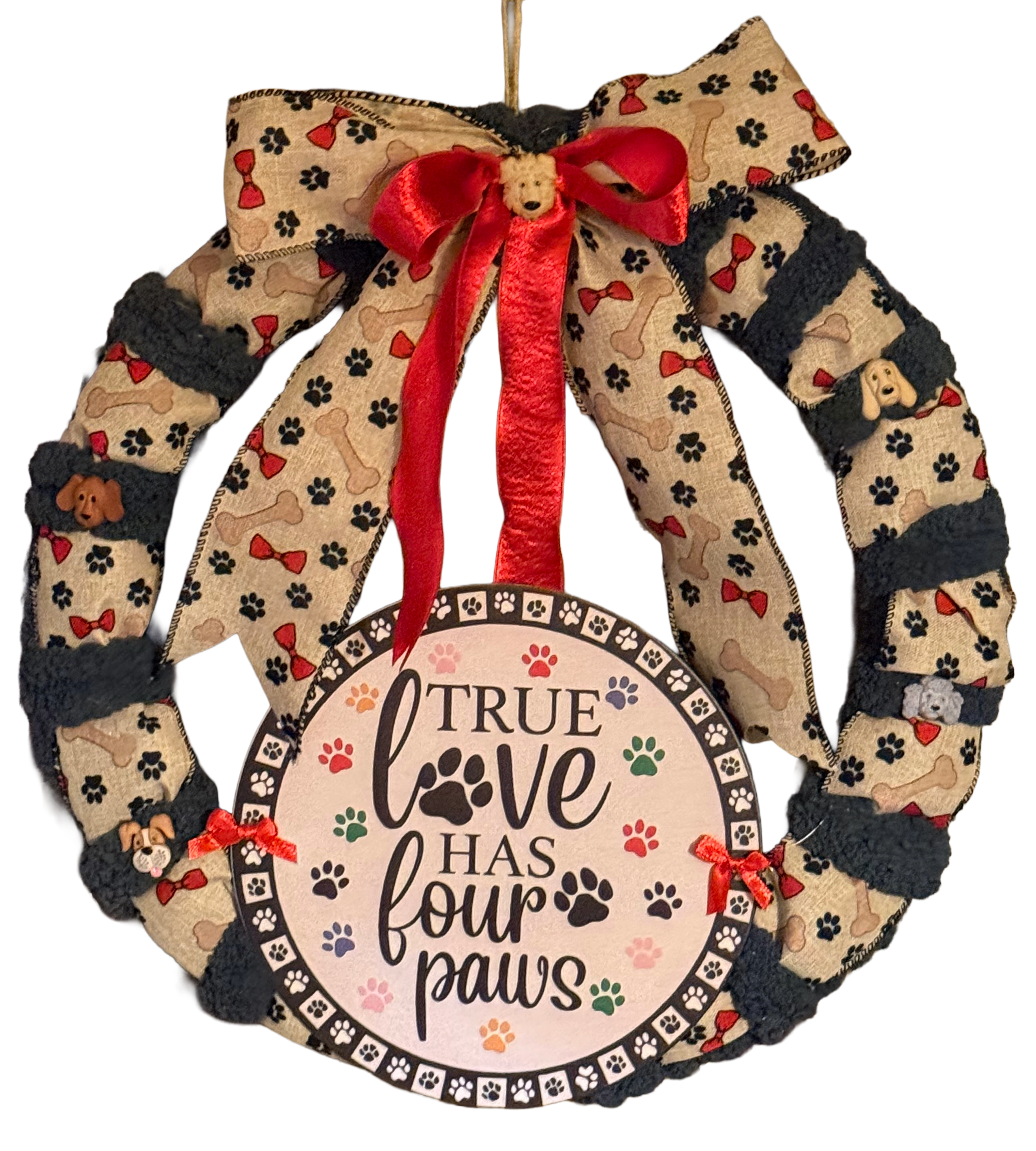 Decorative wreath with a red ribbon and 'True Love Has Four Paws' text on a white background