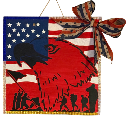 Decorative wall hanging with American flag design and eagle silhouette, featuring a bow on a white background.