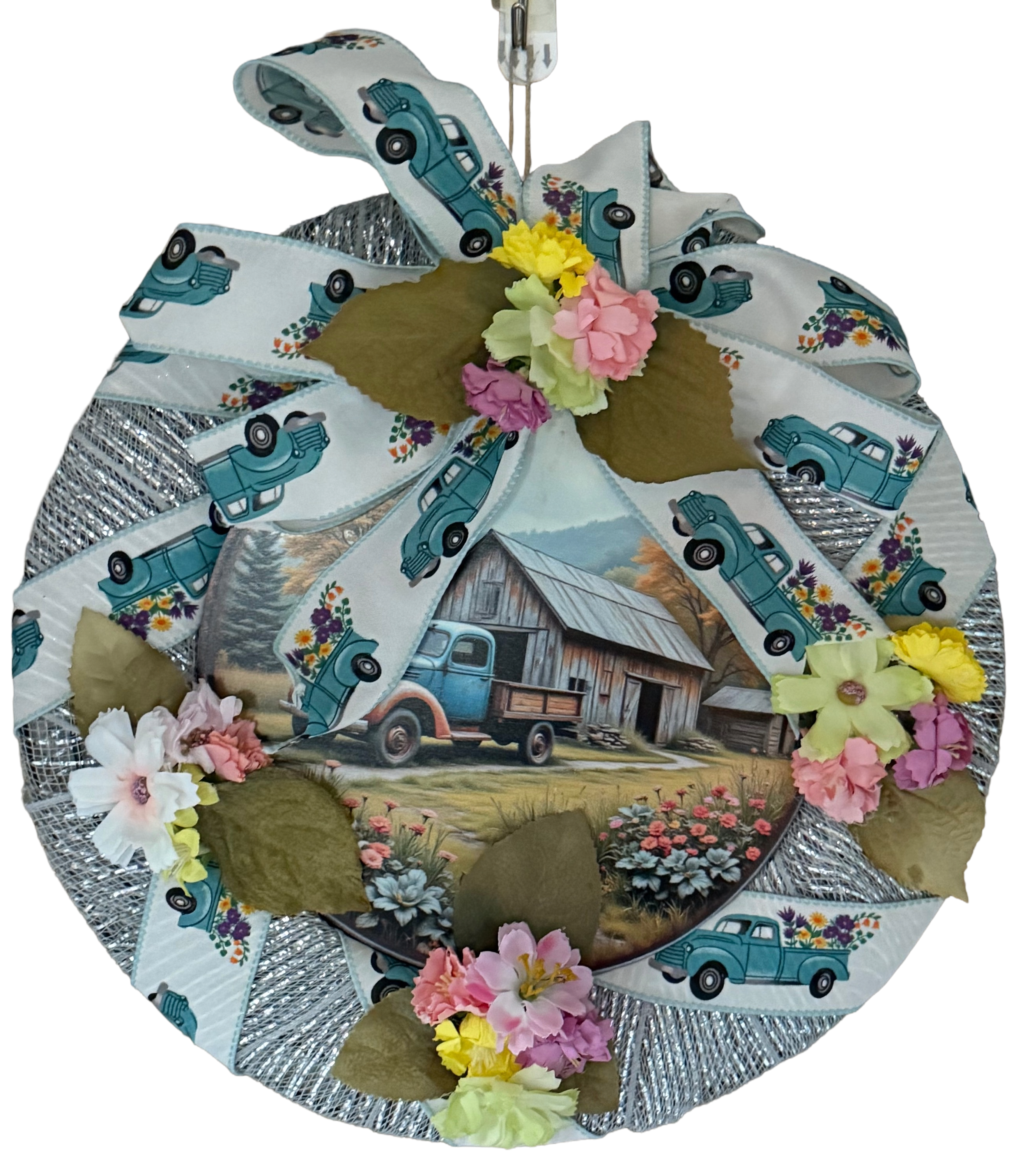 Round wreath with vintage truck and barn design, featuring flowers on a white background.