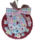 Decorative wreath with plaid ribbon, flowers, and butterflies on a white background