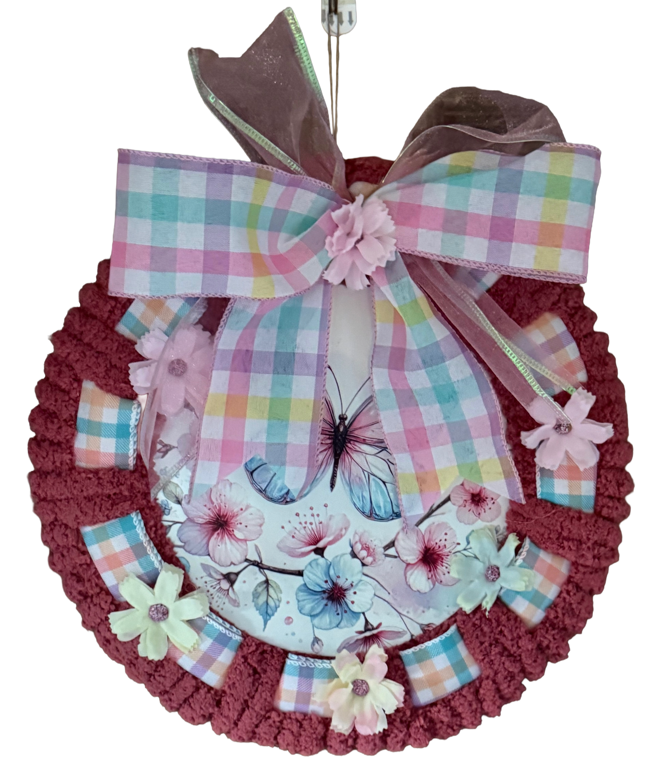 Decorative wreath with plaid ribbon, flowers, and butterflies on a white background