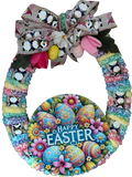 Colorful Easter wreath with a large bow and 'Happy Easter' sign on a white background