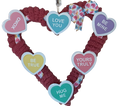 Heart-shaped wreath with colorful conversation hearts on a white background.