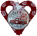 Heart-shaped wreath with a red truck and 'Love is in the Air' text, surrounded by smaller hearts and ribbons.