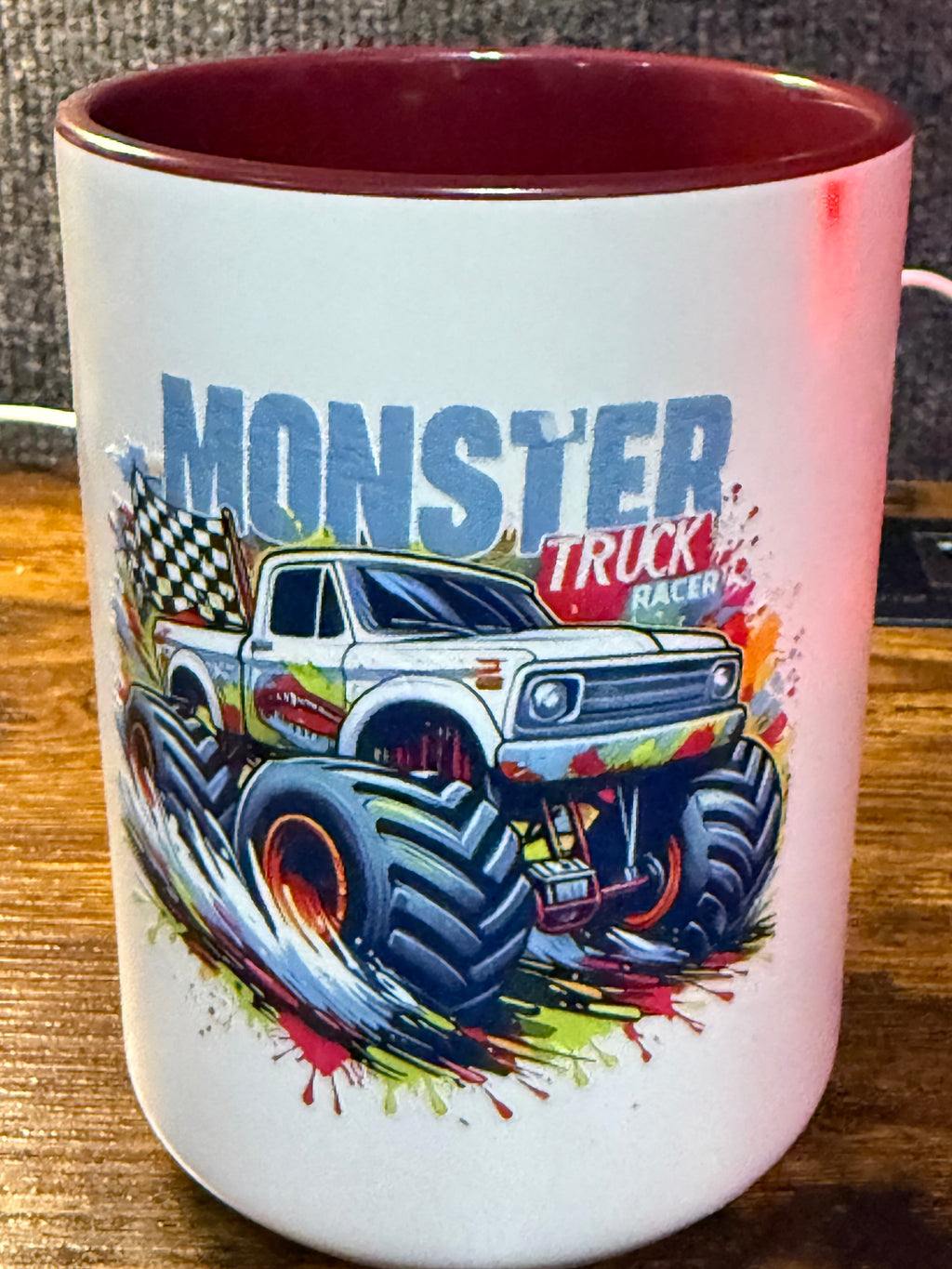 Mug with monster truck design on a wooden surface
