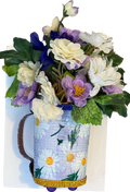 Decorative pitcher filled with flowers on a white background