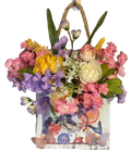 Decorative floral arrangement in a woven basket on a white background