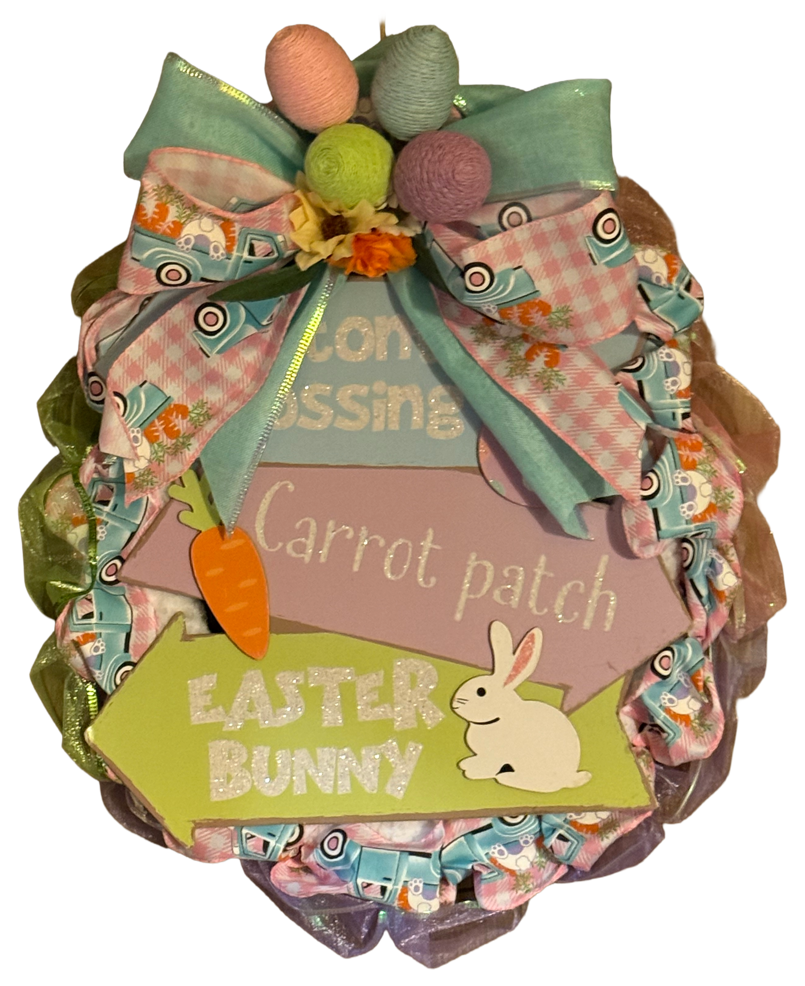 Decorative Easter wreath with colorful ribbons, eggs, and bunny elements on a white background.